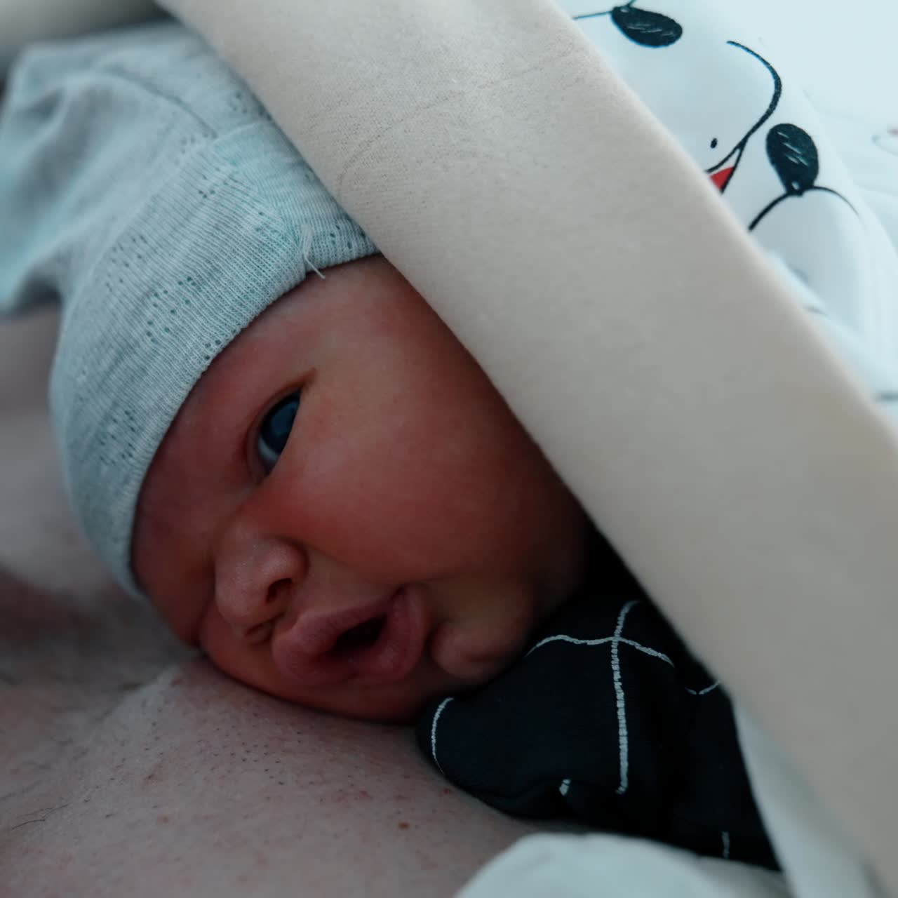 Padre caucasico con la barba che tiene in braccio il suo bambino appena nato. Pratica del contatto pelle a pelle per un bambino nato con taglio cesareo. Primo piano