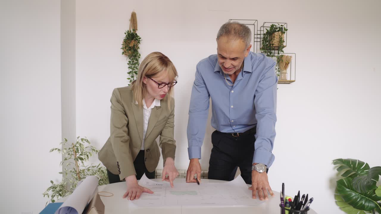 Business Meeting: Architects Discussing Blueprint in the Office