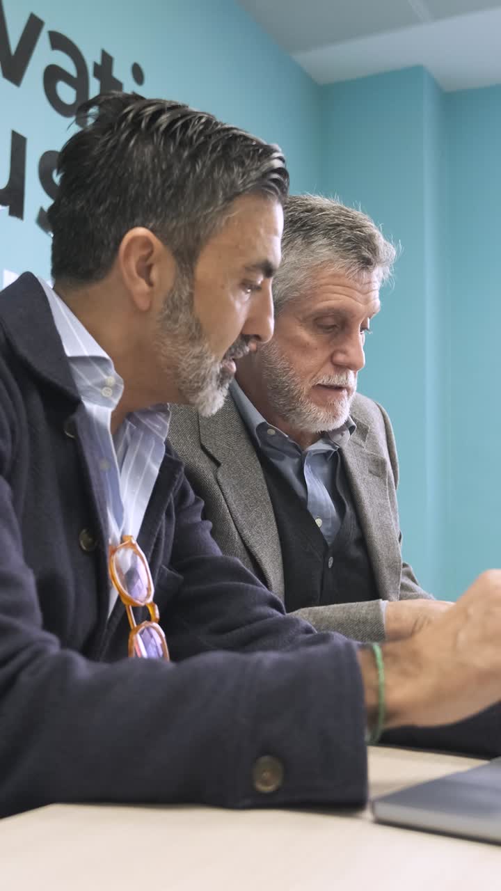 Male managers discussing strategy in creative office