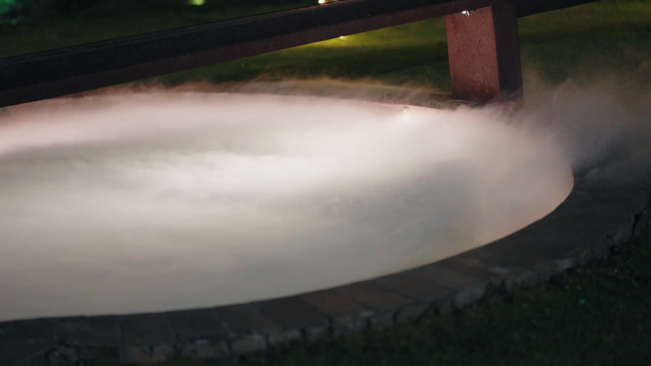 niebla de hielo seco mística que fluye sobre el borde de la piscina por la noche