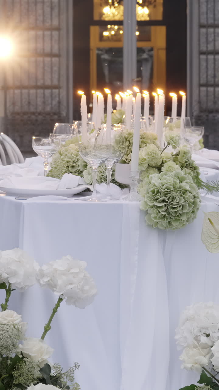 Elegante allestimento della tavola per ricevimento di matrimonio con candele e fiori bianchi