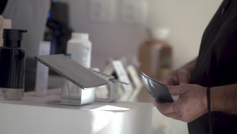 customer entering information at credit card payment terminal at small business