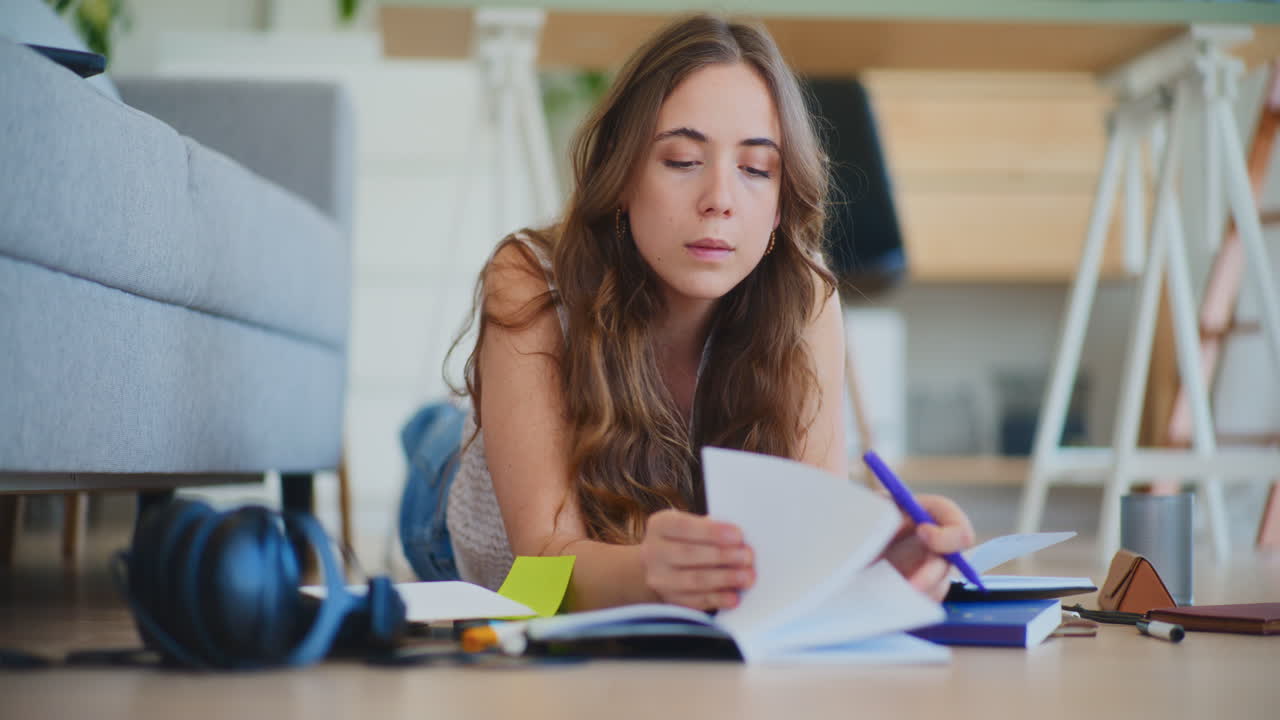Woman Laying on Floor Reading for Exams