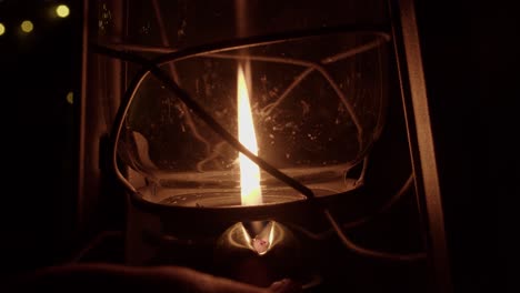 glass globe of traditional oil lamp raised, flame diminished to black