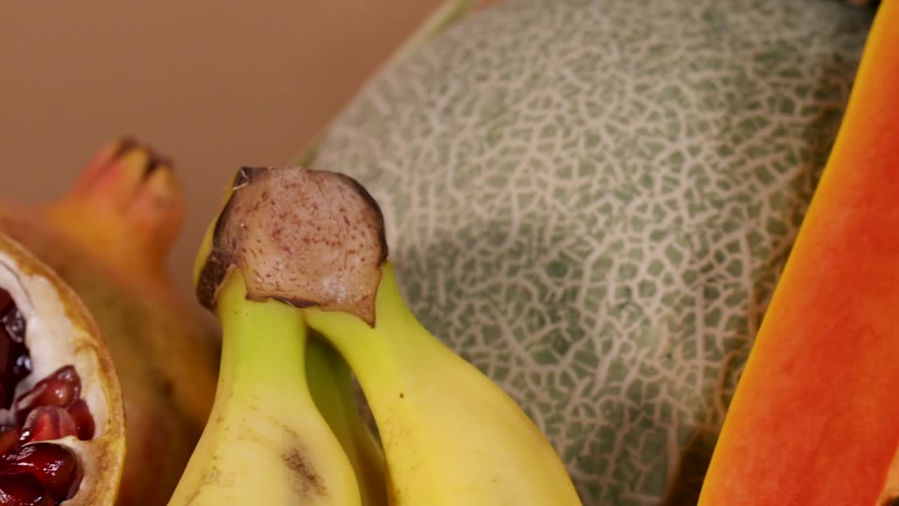 A colorful assortment of sliced tropical fruits including pomegranate, banana, and kiwi, beautifully arranged.