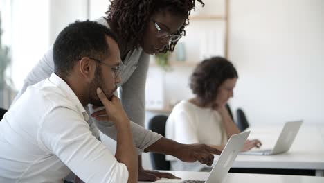 Concentrated-African-American-woman-pointing-at-laptop.