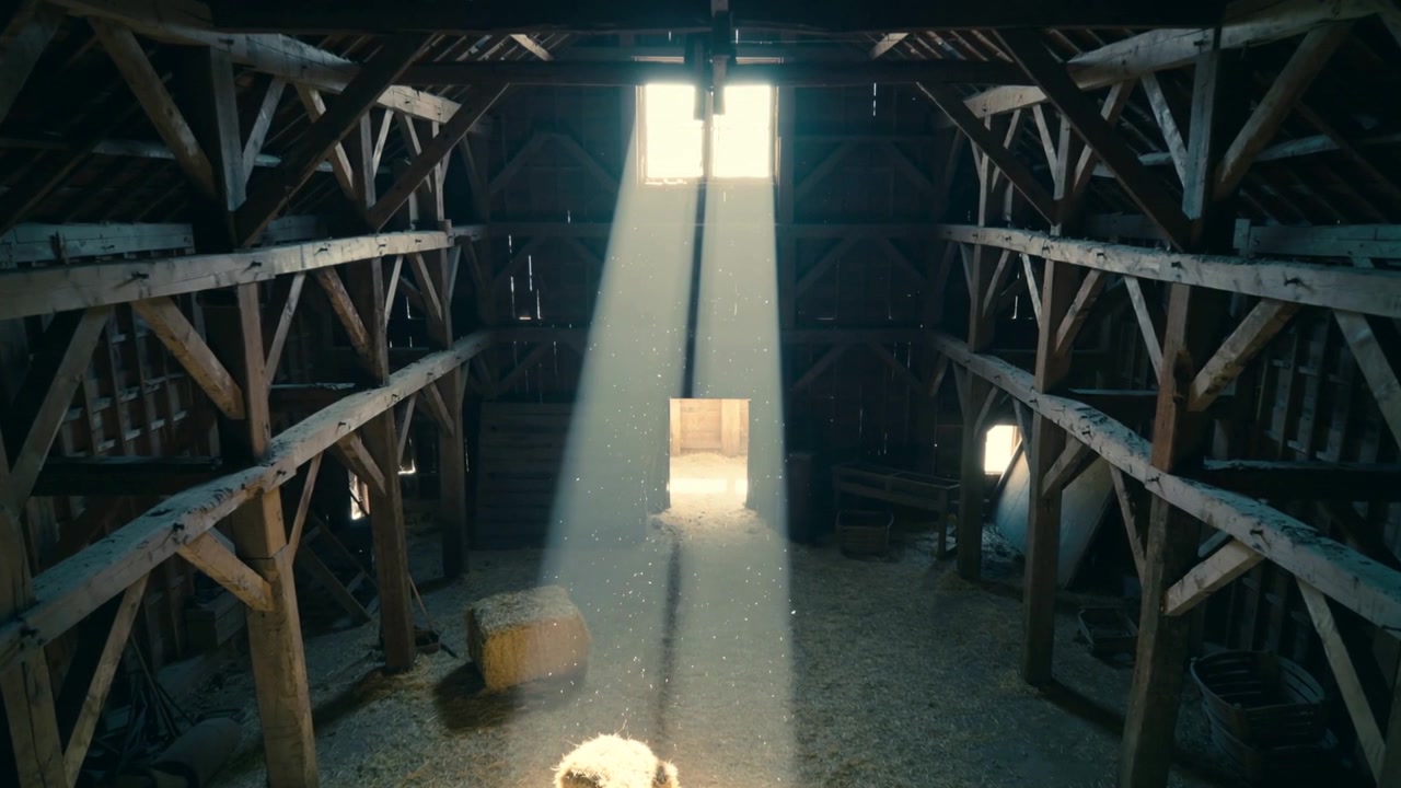 Raio de sol vindo de janela alta iluminando sótão de celeiro, pequena ovelha branca buscando calor perto de fardo de feno.