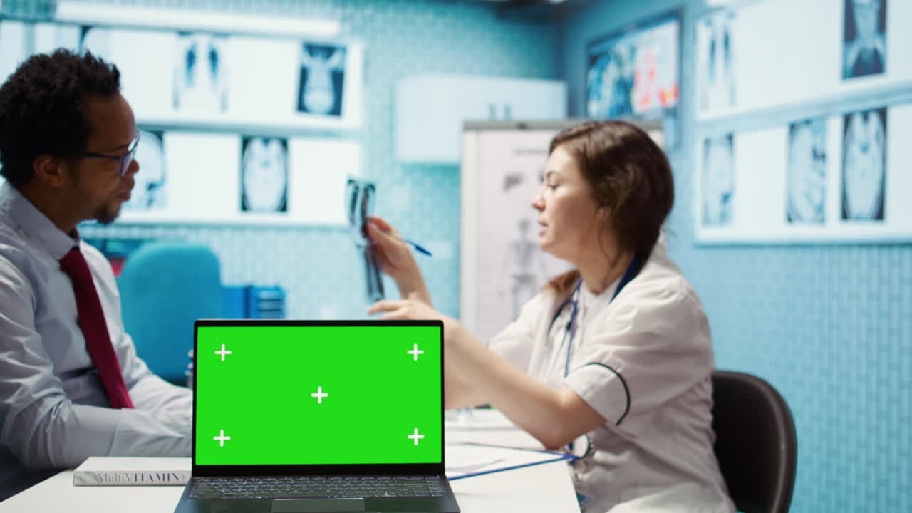 일반 의사와 환자가 기기의 녹색 화면을 보고 있습니다.