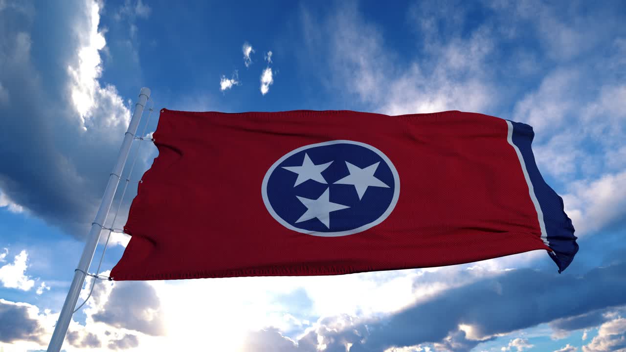 la bandera de tennessee en un asta de bandera ondeando en el viento, fondo de cielo azul. 4k