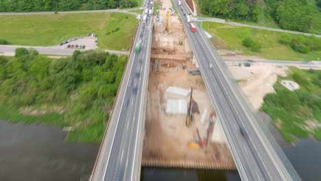 Construction-of-A1-bridge-over-Neris-river-in-Kaunas,-aerial-hyper-lapse-view