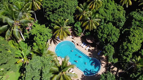 aerial view of a tropical resort swimming pool with people