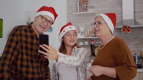 familia feliz con sombrero de santa disfrutando de la temporada de invierno juntos discutiendo con amigos remotos