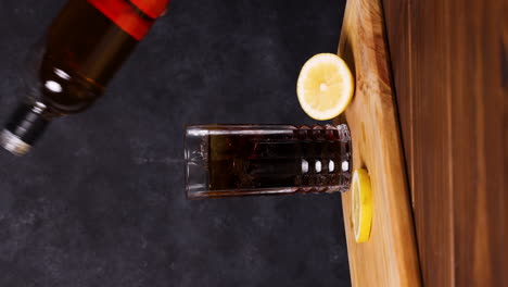 piscola cóctel, bebida típica chilena mesa de madera fondo oscuro chile pisco, hielo y coca