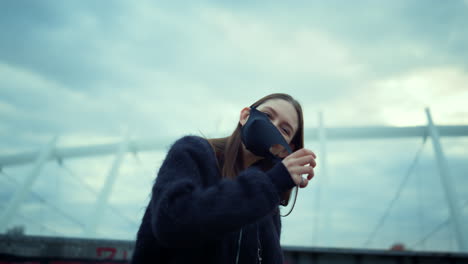 girl wearing protective mask during protest. woman taking off mask from face