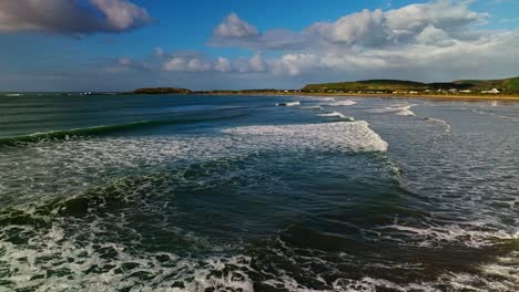 Panoramic-aerial-overview-of-waves-entering-and-crashing-across-bay-entrance,-New-Zealand