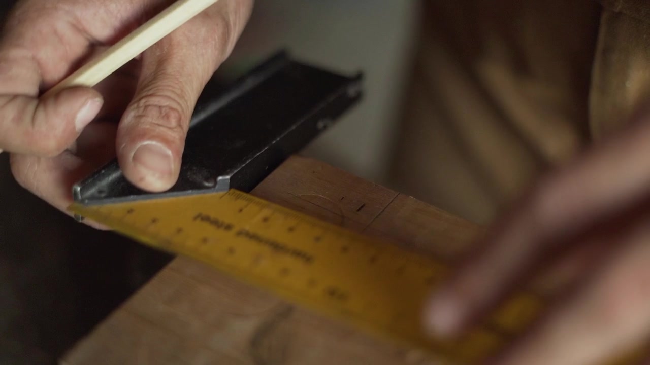Close-Up Carpenter Measuring and Marking Wood for Cutting