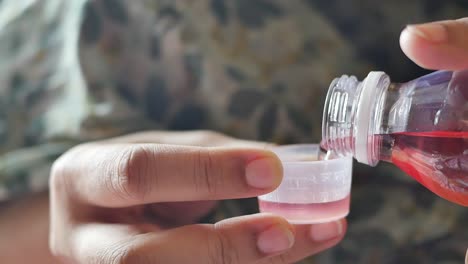 bottle with liquid medicine on hand