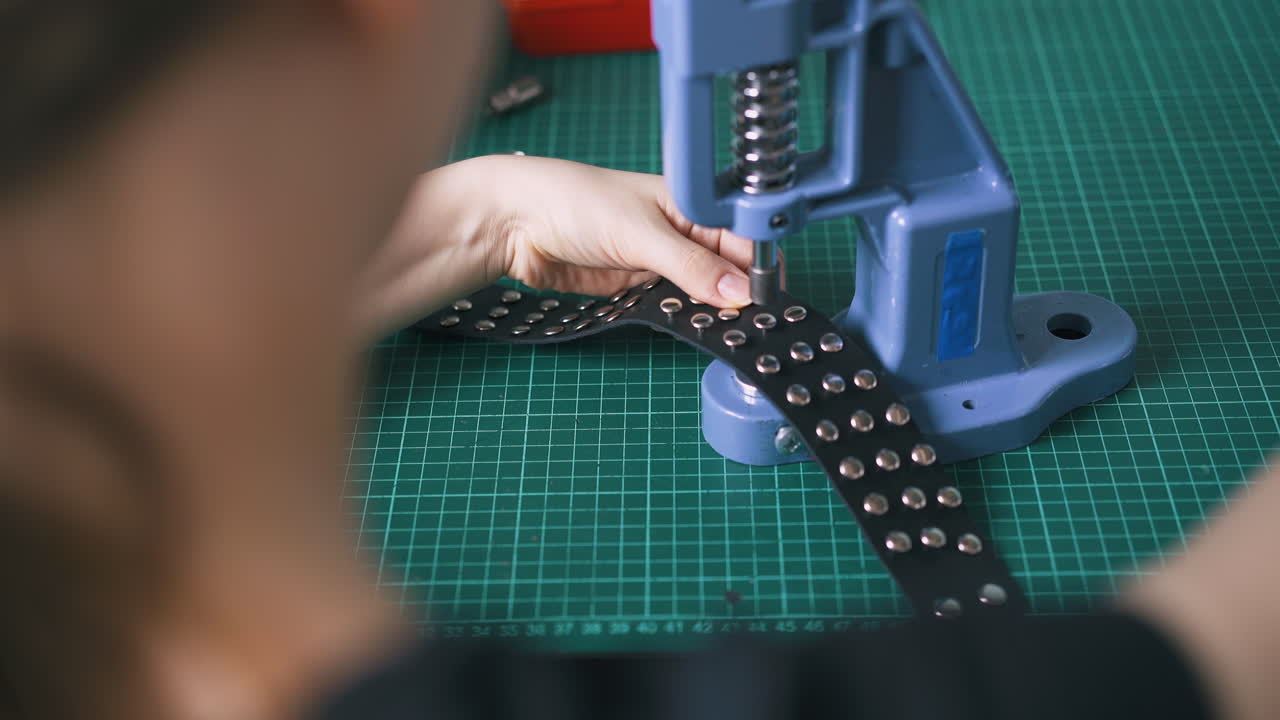 женщина устанавливает металлические аксессуары на черный кожаный хокер