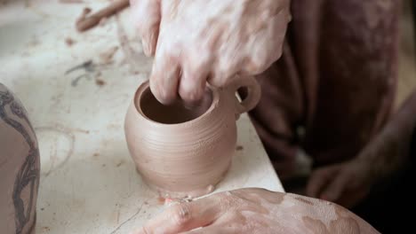 young woman makes a jug of clay. female hands mold pottery