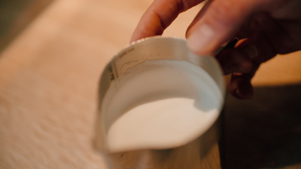 barista enfría la leche para el café