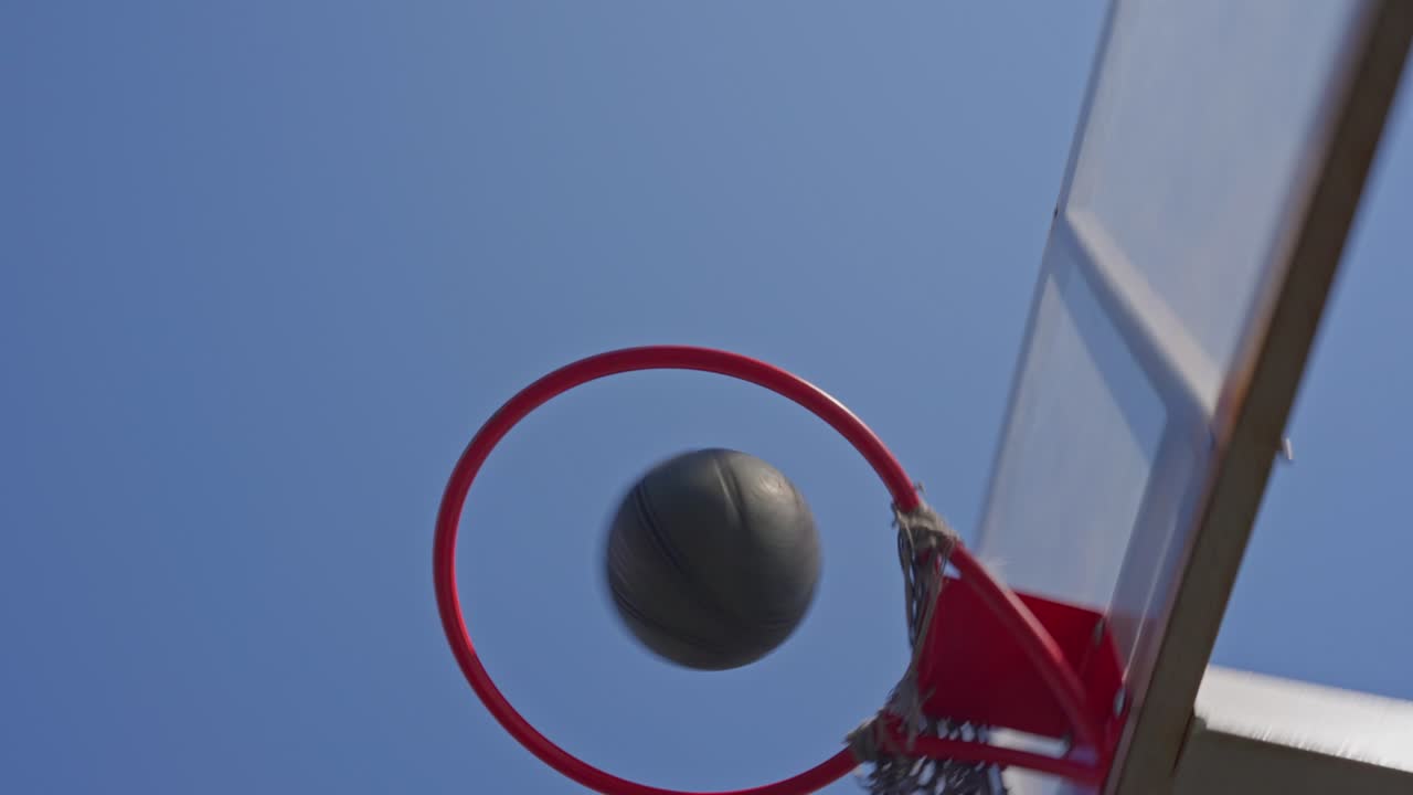 Uomo che palleggia e tira a basket su un campo all'aperto