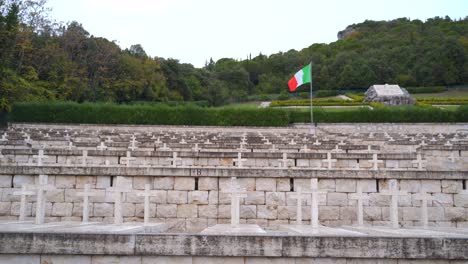 vista de una sola bandera italiana roja, blanca y verde sobre filas de cruz de piedra blanca sobre varias tumbas en el cementerio polaco, monte cassino, italia, estática