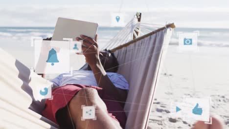 animation of connections over relaxed african american man reading book in hammock on beach