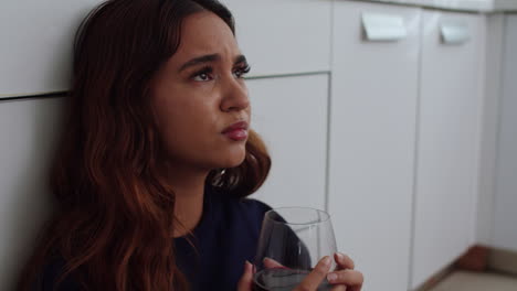unhappy woman drinking red wine at home
