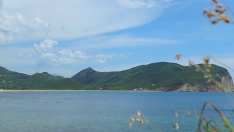 Calm-sea,-blue-sky-with-clouds-and-green-mountains,-Southern-Europe