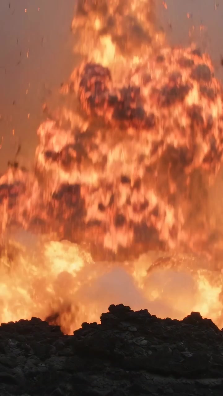 Vertikales Video: Ausbrechende Lavafontäne bildet Feuerball am Schlot, Magma-Schwall schleudert Bomben und Asche aus.