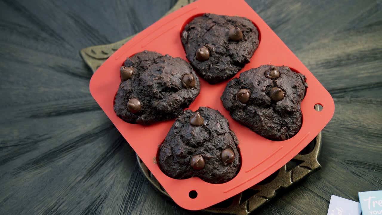 Luftfoto med sakte zoom inn på rødbet-sjokoladebiter-muffins i rød silikonform til Valentinsdagen.