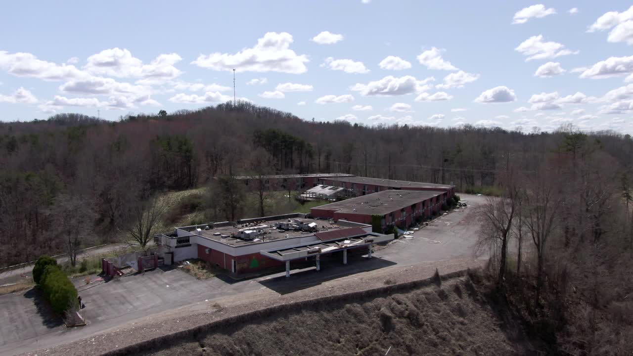 imágenes aéreas de drones orbitando alrededor de un espeluznante hotel y restaurante abandonado en la cima de una colina