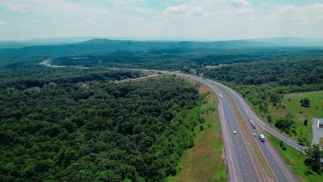 aerial view of a highway winding through a lush green forest