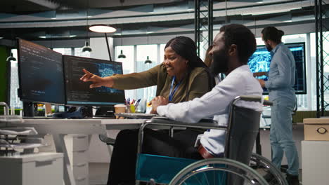startup office programmer in wheelchair talking with colleague, developing ai