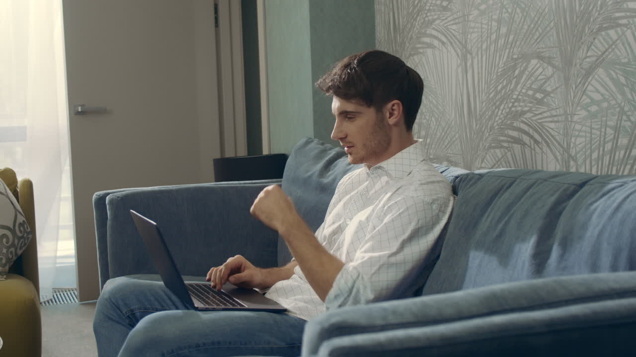 Attractive guy receiving message computer. Smiling man using laptop indoors.