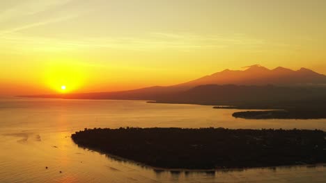 El-Sol-Se-Pone-Sobre-Una-Gran-Masa-De-Agua,-Creando-Una-Luz-Dorada-En-La-Montaña-De-Indonesia