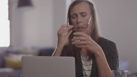 mujer con gafas y contenedor de medicamentos en casa