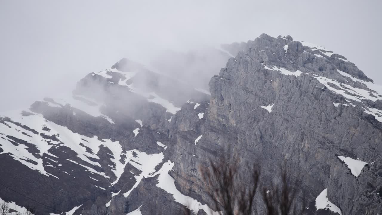 Montanha nevada e nevoenta nos Alpes. Imagem em câmera lenta.