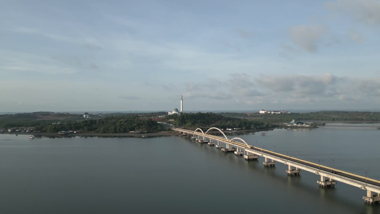 Cinematic drone flight over Dompak Bridge to Masjid Raya Nur Ilahi at sunrise. Located in Tanjung Pinang, Indonesia - Tanjungpinang, Indonesia