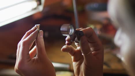 Close-up-of-hands-of-caucasian-female-jeweller-making-jewelry-in-workshop