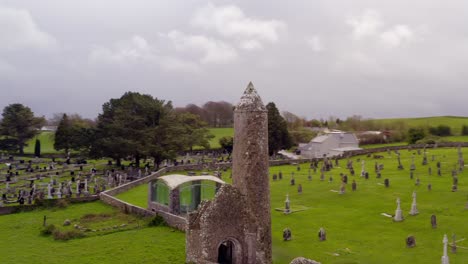 fotografía aérea dinámica de clonmacnoise, destacando el cementerio y la torre redonda