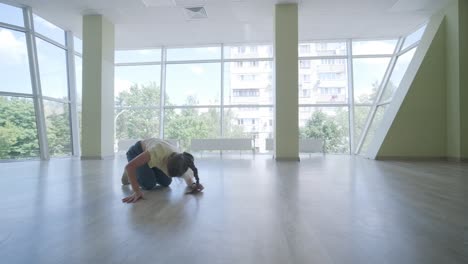 una chica joven bailando breakdance en un estudio moderno.