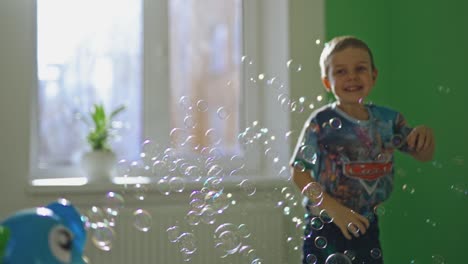 Boy play at home. Boy intdoor playing with soap bubbles