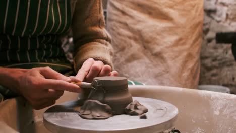 mid section of potter making pot