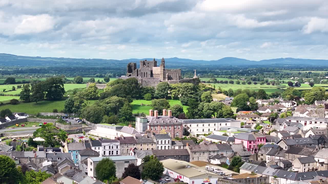 Amazing dolly of Rock of Cashel Castle on hilltop over town buildings. Ireland tourist attraction