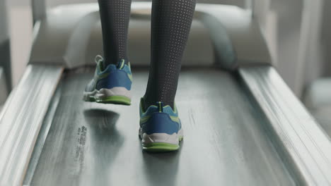 closeup legs running on treadmill in fitness gym. back view of fitness shoes