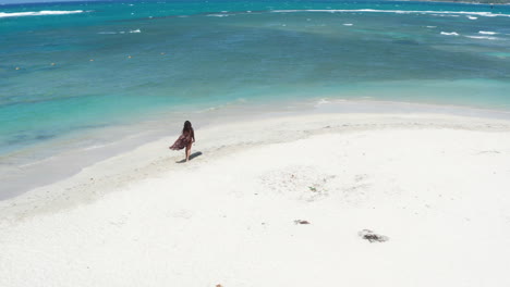 Dolly-Antena-Hacia-Adelante-Hacia-La-Mujer-Turista-En-Bikini-En-La-Playa-De-Arena-Blanca-Olas-Lavando-En-Tierra