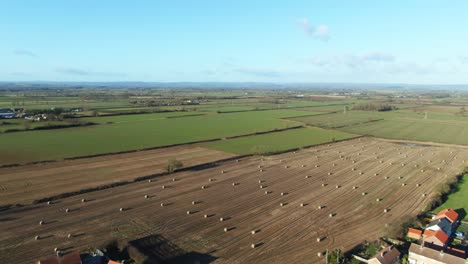 Sunset-over-farmland-with-fields-full-of-hay-bales-after-harvest-with-flat-land-for-miles