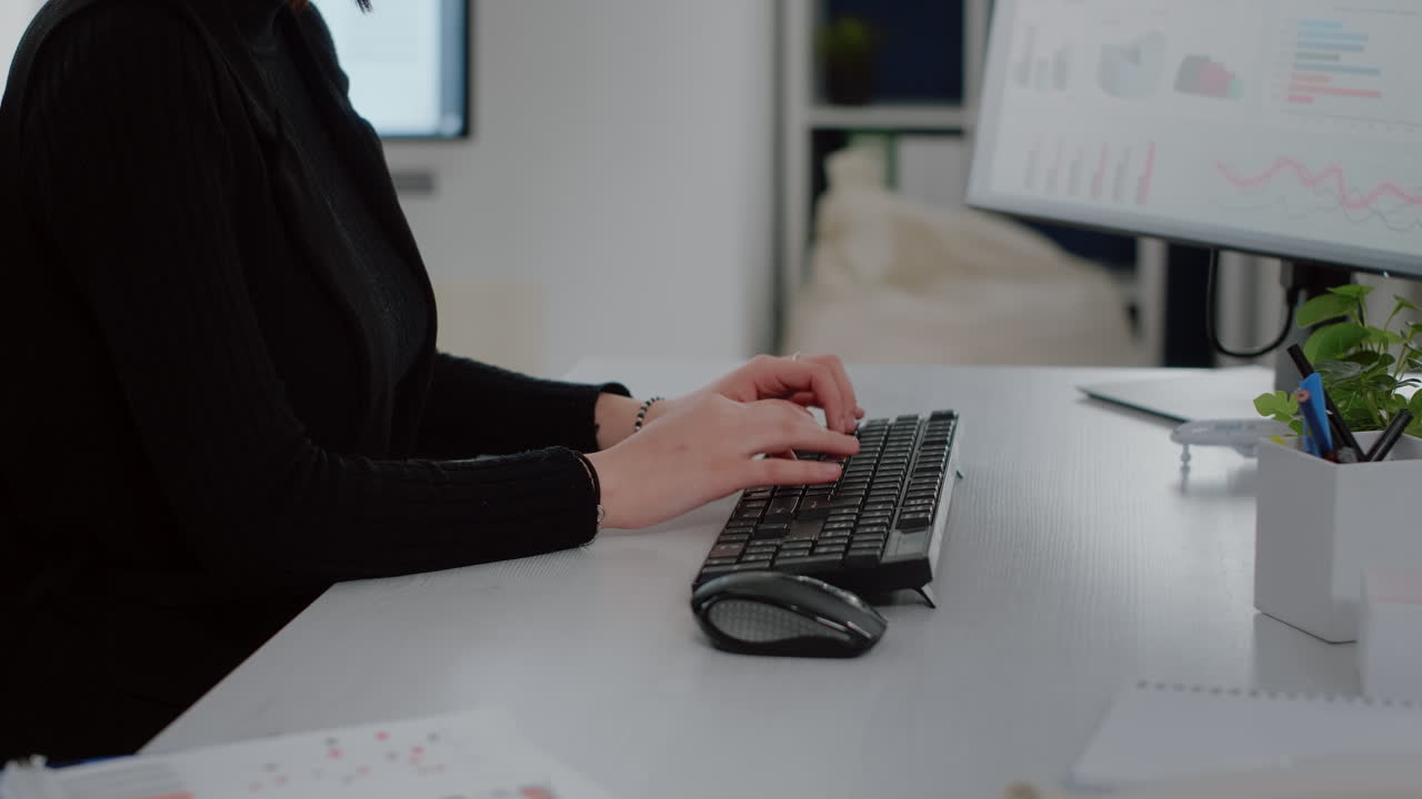 Nærbilde av forretningskvinne som bruker tastatur og datamaskin