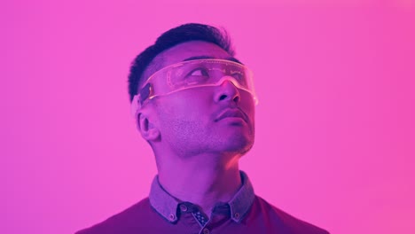 man in futuristic ar/vr glasses looking up in neon light